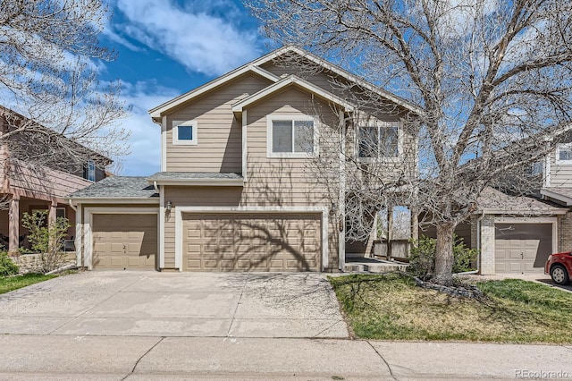 view of front of property with driveway, an attached garage, and a shingled roof