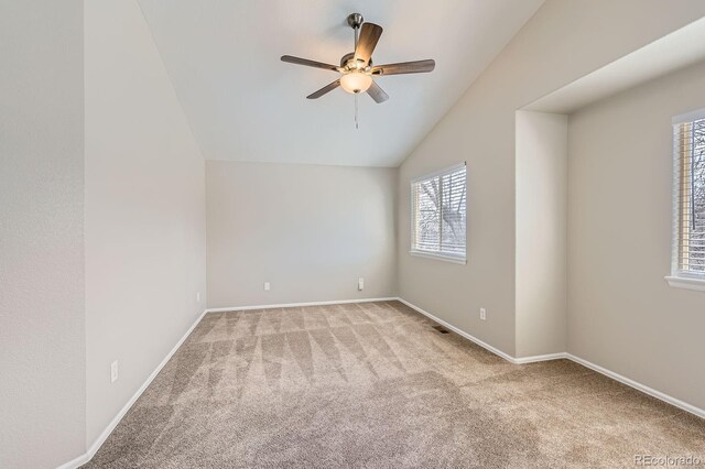 unfurnished room featuring carpet, ceiling fan, lofted ceiling, and baseboards