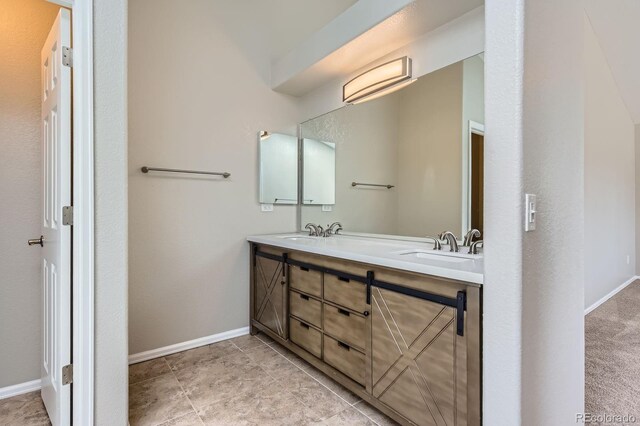 full bathroom featuring baseboards and double vanity
