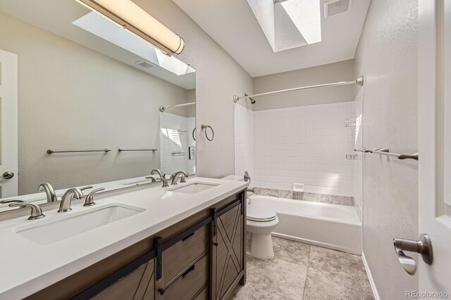 bathroom with a skylight, toilet, double vanity, and washtub / shower combination
