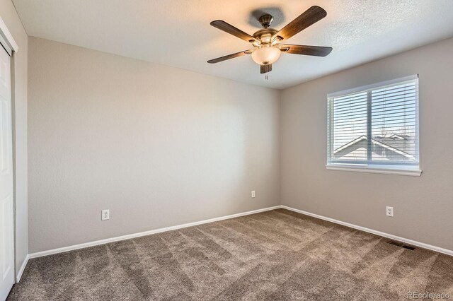 unfurnished room featuring carpet floors, a ceiling fan, and baseboards