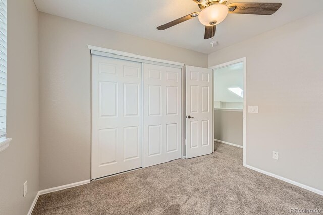 unfurnished bedroom with carpet flooring, a closet, baseboards, and ceiling fan
