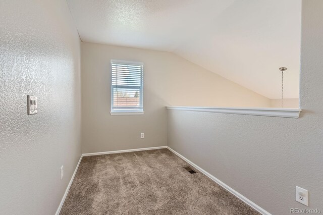 bonus room featuring carpet flooring, lofted ceiling, baseboards, and a textured wall