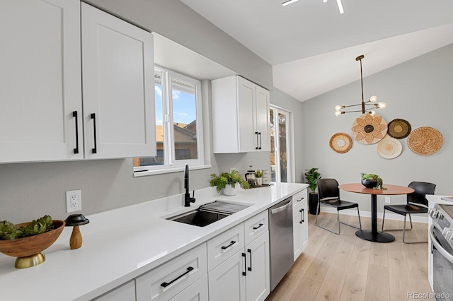 kitchen featuring sink, light wood-type flooring, appliances with stainless steel finishes, pendant lighting, and white cabinets