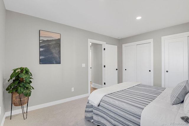 bedroom featuring two closets and light colored carpet