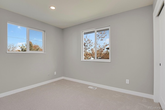 unfurnished room featuring light carpet