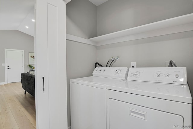 laundry room with separate washer and dryer and light hardwood / wood-style floors