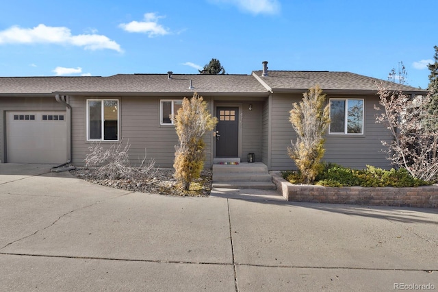 ranch-style house with driveway, a shingled roof, and an attached garage