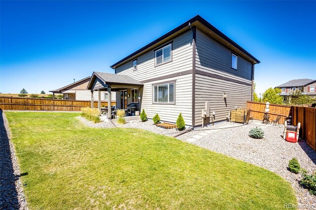 back of house with a patio area and a lawn