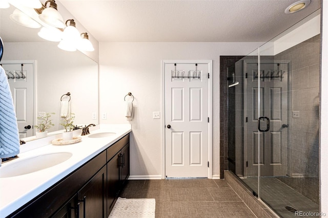 bathroom with tile patterned floors, vanity, walk in shower, and a textured ceiling