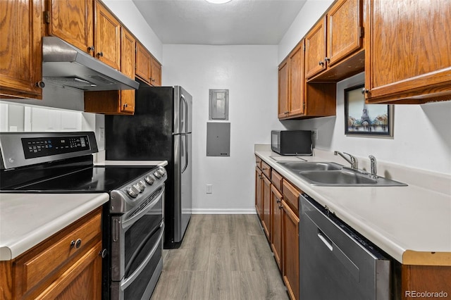 kitchen featuring double oven range, dishwasher, sink, and light wood-type flooring