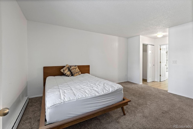 carpeted bedroom with a baseboard radiator and a textured ceiling