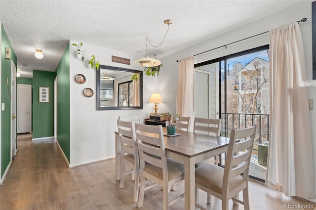 dining room with hardwood / wood-style floors and a textured ceiling