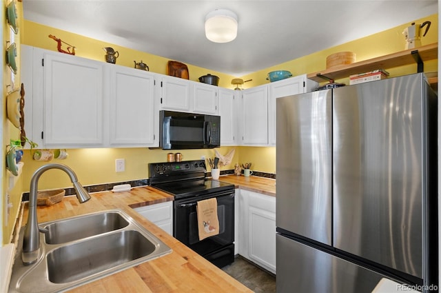 kitchen with black appliances, white cabinetry, sink, and wooden counters