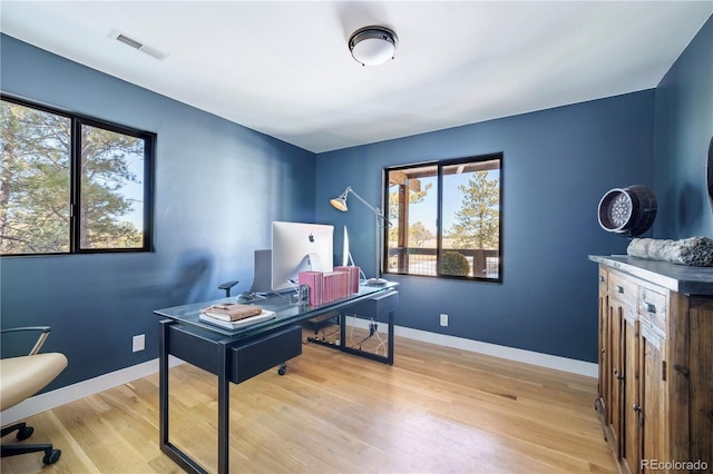 office space with visible vents, baseboards, and wood finished floors