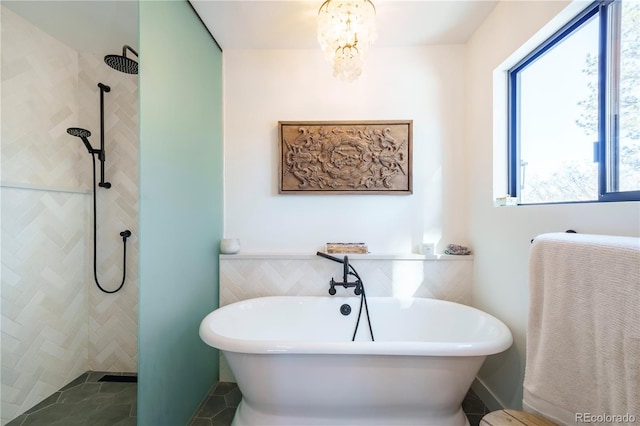 bathroom with a soaking tub, a chandelier, and a walk in shower