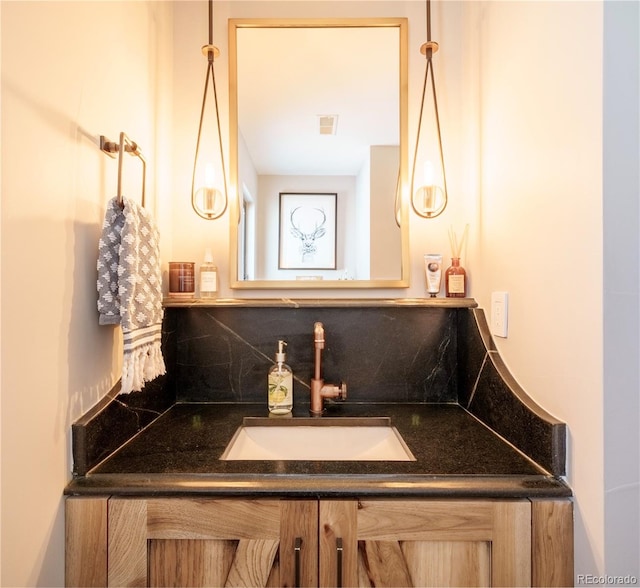 bathroom with visible vents, backsplash, and vanity