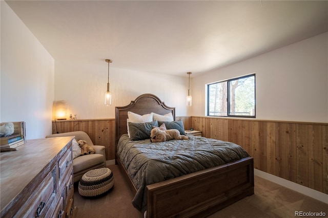 bedroom featuring a wainscoted wall, wood walls, and carpet flooring