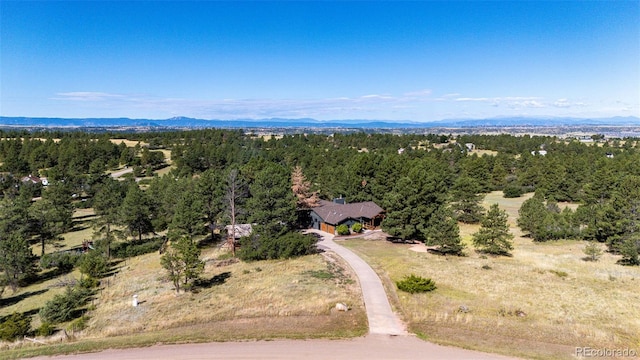 drone / aerial view with a mountain view and a view of trees