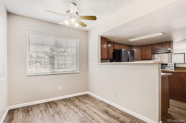 kitchen featuring a textured ceiling, ceiling fan, kitchen peninsula, and appliances with stainless steel finishes