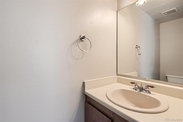 bathroom featuring toilet and vanity