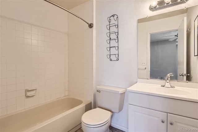 full bathroom with toilet, tiled shower / bath, ceiling fan, and vanity