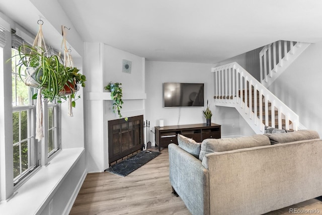 9632 W Chatfield Ave Unit C, Littleton, CO 80128 - living room with healthy amount of natural light, a fireplace with flush hearth, wood finished floors, and stairs