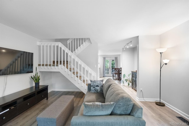 9632 W Chatfield Ave Unit C, Littleton, CO 80128 - living room with stairway, wood finished floors, baseboards, and track lighting