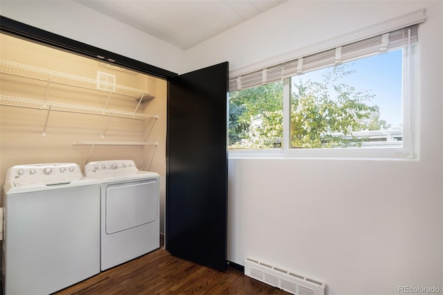 clothes washing area with washer and dryer, dark hardwood / wood-style flooring, and baseboard heating