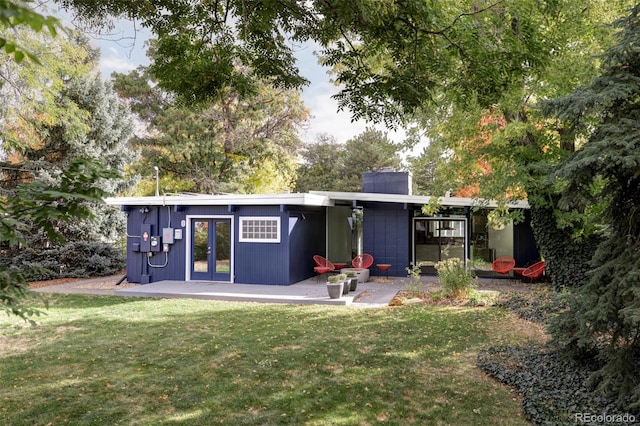 back of house featuring a yard and french doors