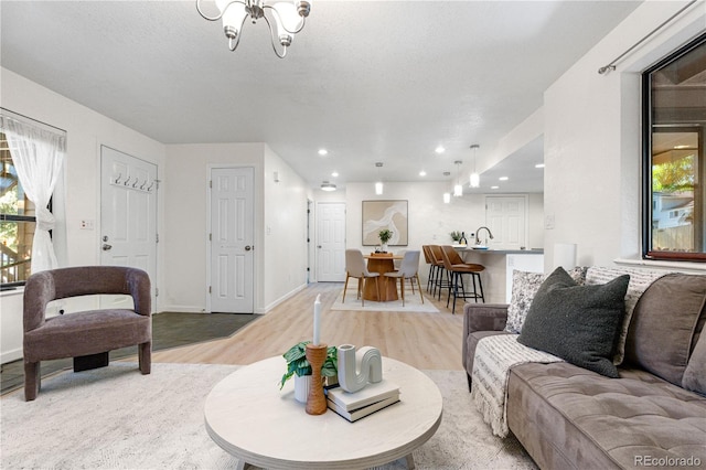 9587 W 89th Cir, Broomfield, CO 80021 - living room featuring light wood-style flooring, a chandelier, plenty of natural light, and recessed lighting