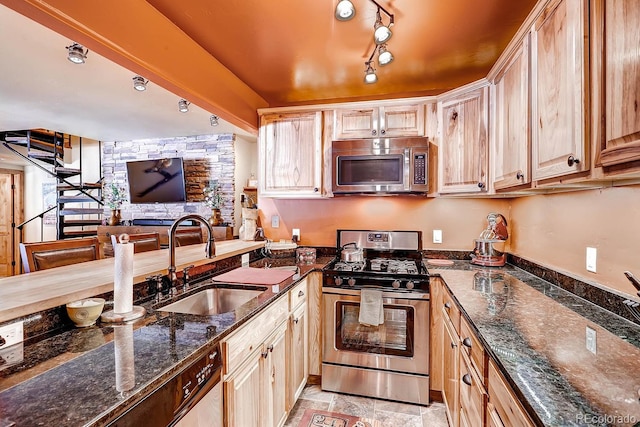 1937 Soda Ridge Rd Unit 1132, Dillon, CO 80435 - kitchen featuring appliances with stainless steel finishes, light brown cabinetry, dark stone counters, and a peninsula