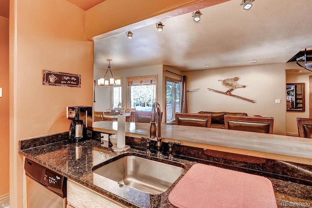 1937 Soda Ridge Rd Unit 1132, Dillon, CO 80435 - kitchen with stainless steel dishwasher, dark stone countertops, and a chandelier
