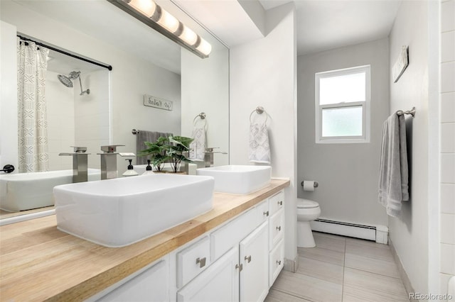 full bath featuring a baseboard radiator, a sink, toilet, and double vanity