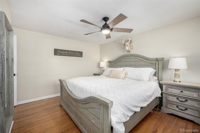 bedroom with a ceiling fan, baseboards, and wood finished floors