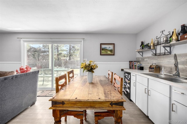 dining space featuring light wood-type flooring and indoor wet bar