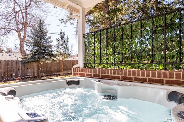 view of patio / terrace featuring a hot tub and fence