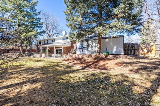 rear view of house with a yard and fence