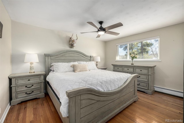 bedroom with baseboards, ceiling fan, baseboard heating, and wood finished floors