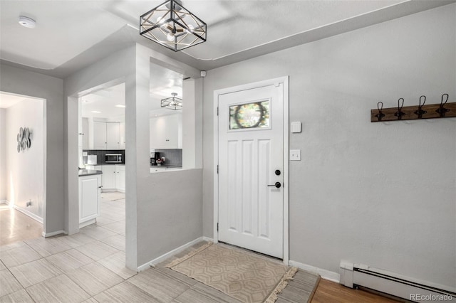 entryway with an inviting chandelier, baseboards, and baseboard heating