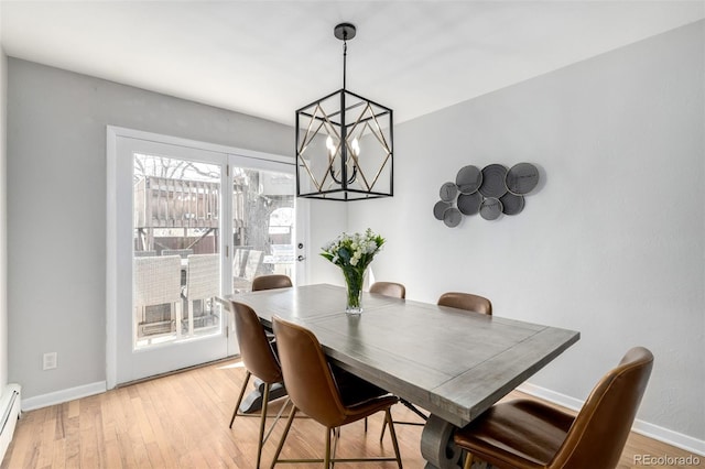 dining room with a baseboard heating unit, a chandelier, light wood-style floors, and baseboards