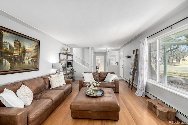 living area with light wood-type flooring, a baseboard radiator, and a baseboard heating unit