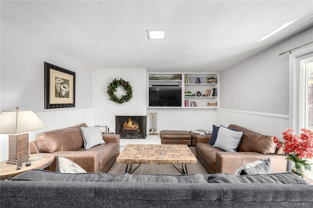 living area featuring radiator, a fireplace, and wainscoting