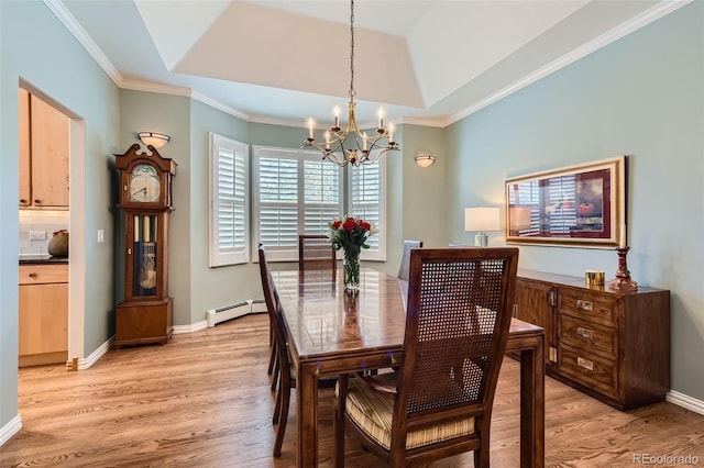 dining space featuring a baseboard heating unit, a chandelier, light wood-style floors, crown molding, and baseboards