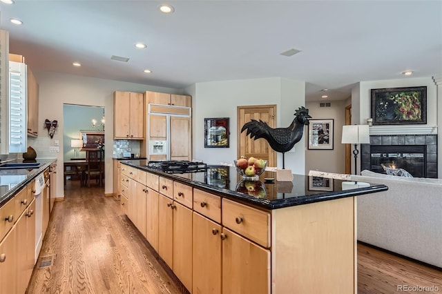 kitchen featuring light brown cabinetry, a center island, light wood-type flooring, appliances with stainless steel finishes, and recessed lighting