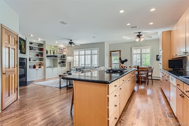 kitchen with a ceiling fan, gas cooktop, a kitchen island, recessed lighting, and light wood-type flooring