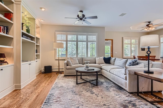 living area with ceiling fan, a baseboard radiator, and light wood-type flooring