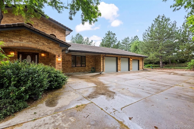 7351 Poppy Way, Arvada, CO 80007 - view of home's exterior with a garage, brick siding, and concrete driveway