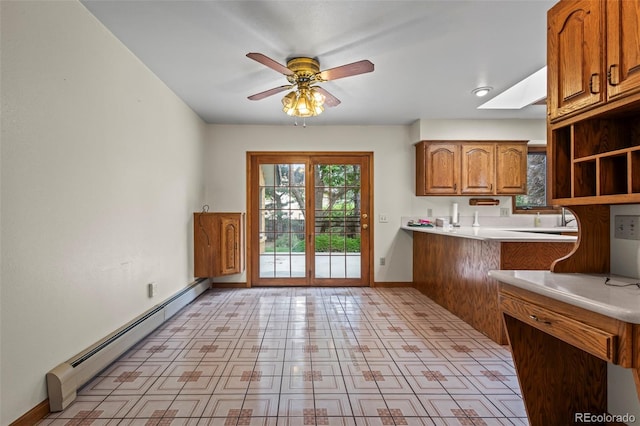 7351 Poppy Way, Arvada, CO 80007 - kitchen with a baseboard radiator, brown cabinets, open shelves, light countertops, and ceiling fan