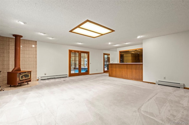 7351 Poppy Way, Arvada, CO 80007 - unfurnished living room with baseboard heating, a baseboard heating unit, a wood stove, a textured ceiling, and carpet